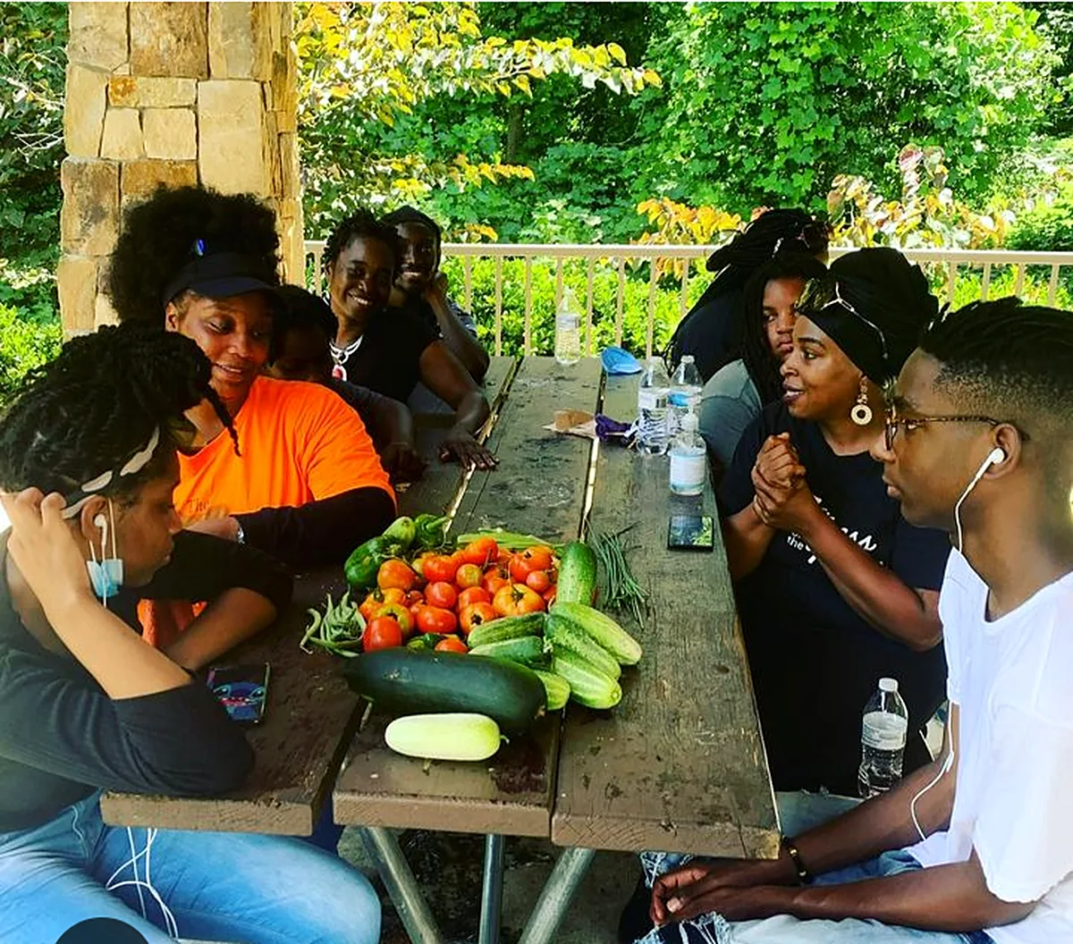 Community members sharing a meal outdoors with fresh produce